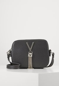 Borsa a tracolla nera con texture e forma rettangolare, con un frangia in metallo argentato e dettaglio con logo "V" sul davanti. Incluso un manico regolabile.