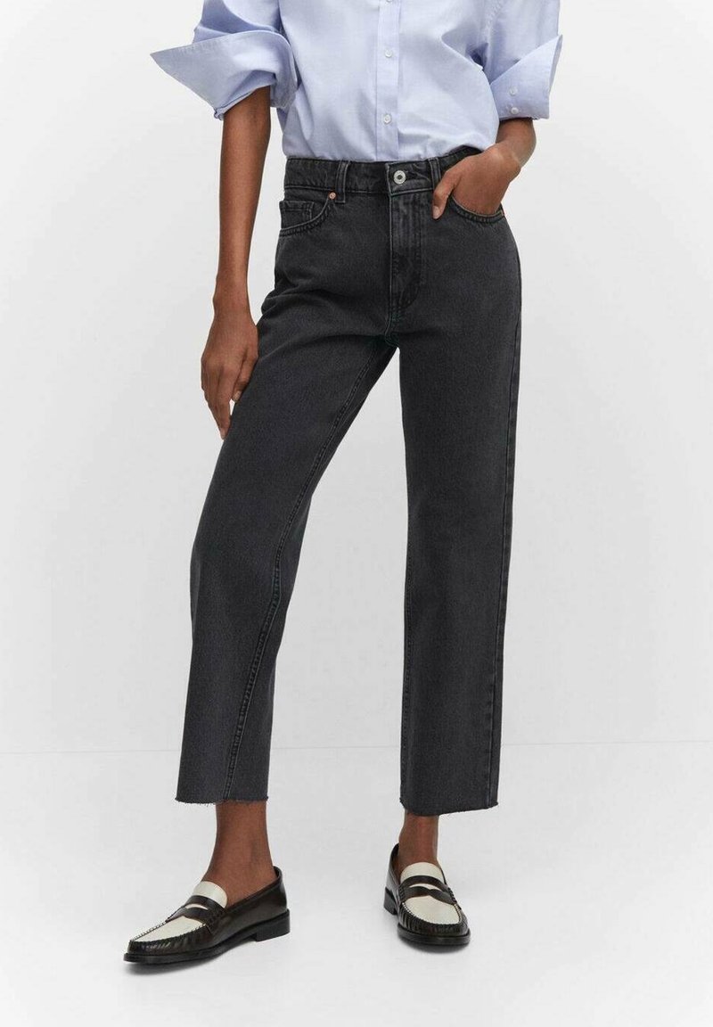 Vaqueros negros de talle alto con corte de pierna recta, que cuentan con cierre de botones, bolsillos delanteros y detalle de dobladillo sin rematar.