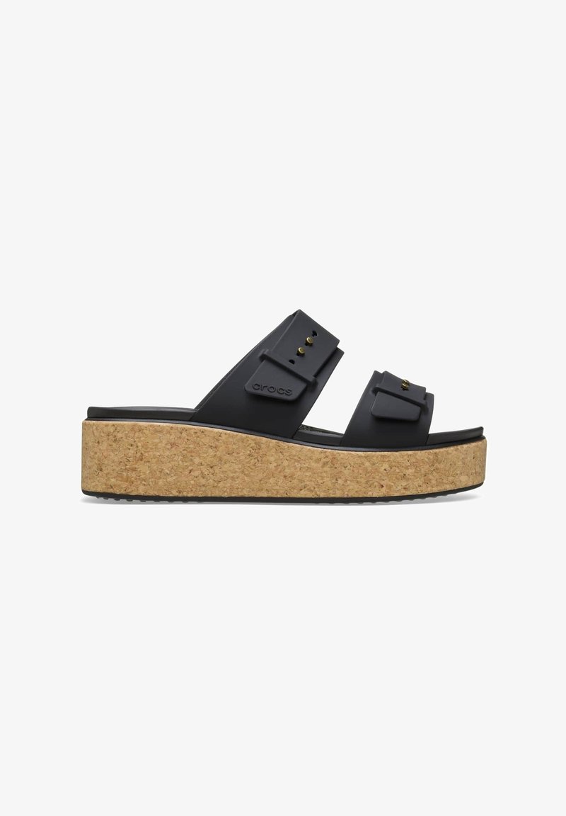 Sandale plateforme noire avec semelle en liège, deux brides ajustables avec des clous dorés et un logo de marque sur la bride supérieure.