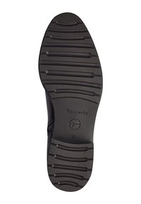 Suela de zapato negra con un patrón texturizado, que presenta múltiples estrías de agarre. La marca "Tamaris" está estampada, junto con el tamaño "37."