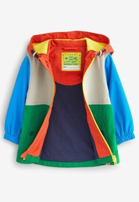 Farverig børnejakke med en orange hætte, blå ærmer, grøn og beige krop, marineblå indvendig, og et mærke med tekst inde i kraven.