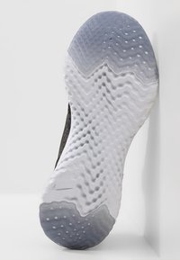 Suela de zapato Nike en ombré negro y blanco. Diseño texturizado con patrones ondulados y puntos de agarre circulares. Bordes limpios y suaves.