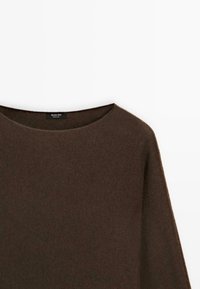 Maglia lavorata a maglia marrone scuro con maniche lunghe e scollatura rotonda, esposta su uno sfondo bianco.