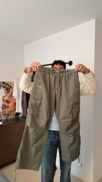 Cargo nohavice olivovo zelenej farby s elastickým pásom, sťahovaním na šnúrku a dvoma bočnými vreckami. Materiál pôsobí ľahko a má mierne textúrovaný povrch.