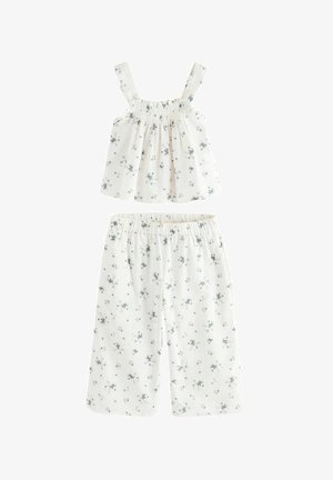 Conjunto de dos piezas en blanco con flores, que incluye una parte superior de tirantes ajustables con fruncido y pantalones cortos de corte holgado decorados con pequeñas flores azules.