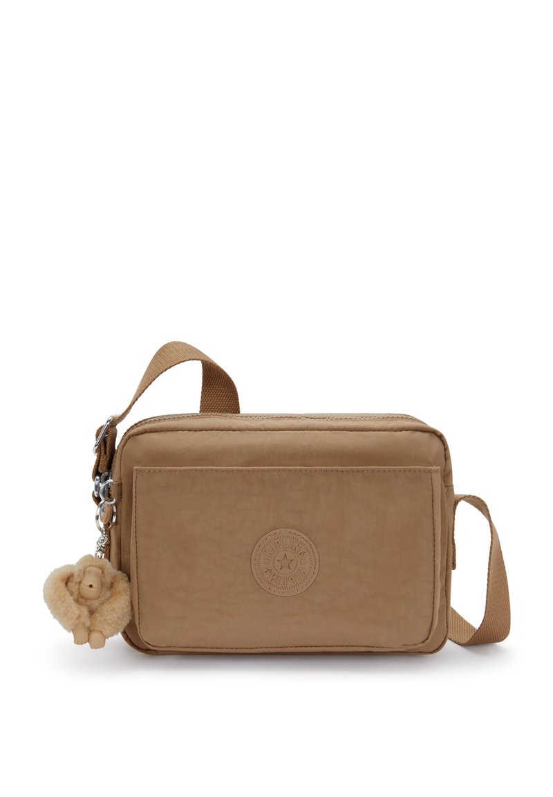 Lille rektangulære brune crossbody taske med frontlomme med lynlås, justerbar rem og en fluffy abe-nøglekæde hængende fra side-lynlåsen.