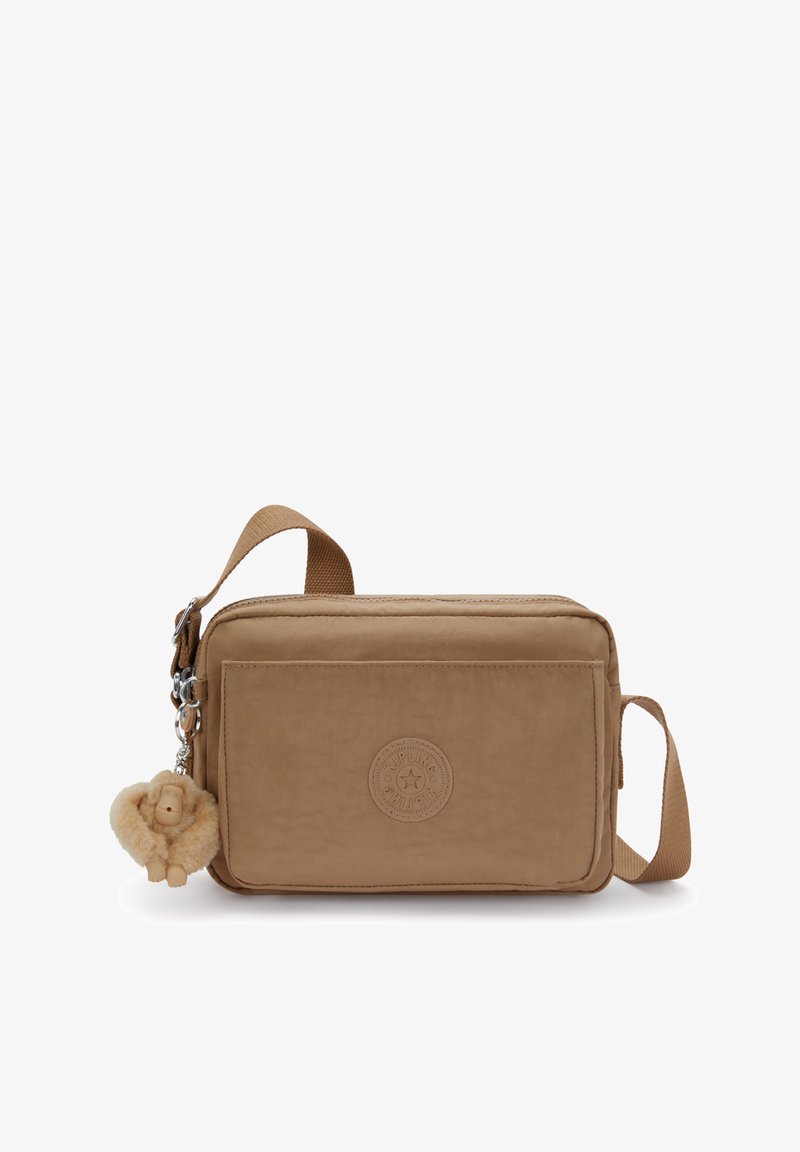 Lille rektangulære brune crossbody taske med frontlomme med lynlås, justerbar rem og en fluffy abe-nøglekæde hængende fra side-lynlåsen.
