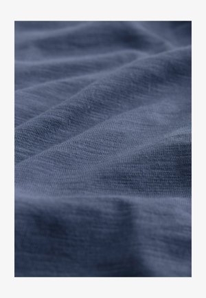 Tumesinine kangas pehme ja tekstuurne pind, millel on peened, ebaühtlased lained ja kerge, hingav omadus.