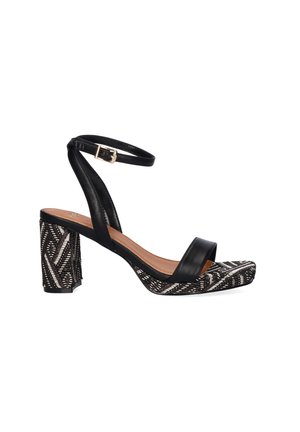 Sandalia negra con pulsera en el tobillo, tacón de bloque y suela y tacón con diseño tribal, con una delgada correa delantera y hebilla dorada.