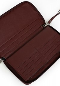 Bordeaux leren portemonnee, met ritssluiting, voorzien van kaarthouders en een gestructureerde binnenkant. Inclusief een polsband en accenten van zilverkleurig metaal.