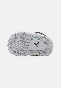 Black sneaker sole with a grey rubber outsole. Features textured patterns for grip and a black logo at the center.