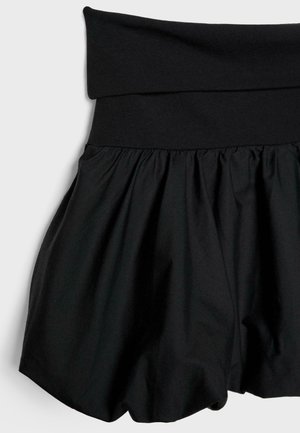 Zwarte shorts met een brede, gevouwen tailleband. Gemaakt van een gladde stof, met een uitlopende pasvorm en een zachte textuur.