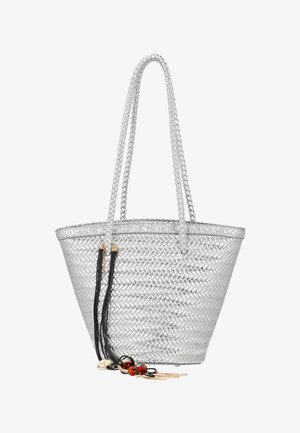 Sac fourre-tout tissé argenté avec poignées tressées et pampilles décoratives noires ornées de perles et de charms dorés accrochées sur un côté.