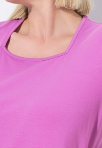 Fialový krátký rukáv top s kulatým výstřihem. Vyrobeno z hladkého, lehkého materiálu; má jednoduchý, bezešvý design.