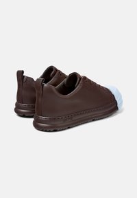 Ruske nahkakengät valkoisella kumipohjalla ja ruskealla pohjalla. Ominaisuuksiin kuuluvat pyöreä muotoilu, nauhoilla varustettu etuosa ja teksturoitu sisävuori.