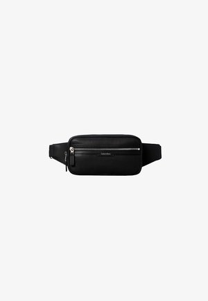 Sort tekstureret læder bæltetaske med to sølv lynlåse, justerbar rem og subtilt Calvin Klein logo på frontlommen.