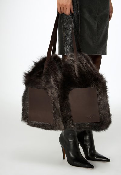 Borsa tote in eco-pelliccia marrone scuro con dettagli in pelle e due tasche laterali rettangolari. Tessuto liscio, doppi manici e design spazioso.