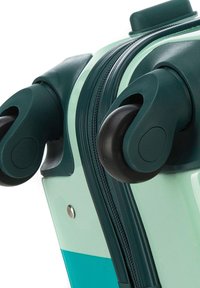 Maleta rígida en verde menta y verde oscuro. Presenta ruedas dobles, un cierre de cremallera y un acento de botón metálico. Textura suave.