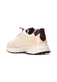 Zapatilla beige con un panel texturizado de patrón de cocodrilo, acentos marrones, cordones en la parte frontal, cuello acolchado y una suela blanca gruesa.