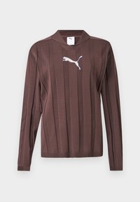 Καφέ πουλόβερ μακρυμάνικο με κάθετες υφασμάτινες ρίγες και λευκό λογότυπο Puma στο κέντρο του στήθους πάνω σε μονόχρωμο φόντο.