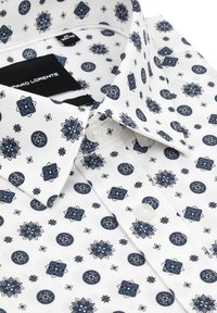 Biała koszula z misternym niebieskim kwiatowym oraz okrągłym wzorem. Klasyczny kołnierzyk, perłowe guziki oraz miękka bawełniana faktura.