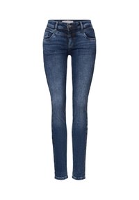 Vaqueros ajustados de denim azul oscuro, con una cintura alta, bolsillos frontales y un ligero desgaste. Las costuras son contrastantes, realzando el diseño.