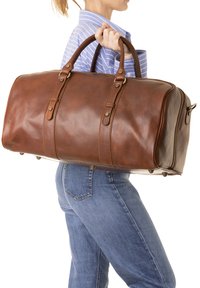 Sac de voyage en cuir marron avec doubles poignées, accessoires en métal, fermeture éclair sur le côté et détails de couture subtils ; texture lisse avec une forme structurée.