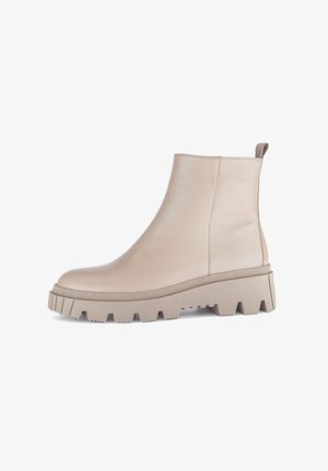 Beige leather ankle boots with a smooth surface, chunky gray rubber sole, and ridged texture, featuring a rear loop for easy wear.