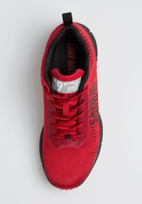 Rote Sport Schuh mit atmungsaktivem Mesh-Obermaterial, schwarzer Gummisohle, strukturiertem Design und Logo-Details an der Seite und Zunge.