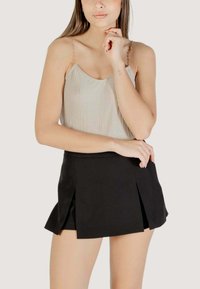 Gonna mini plissettata nera abbinata a un top smagliante leggero con spalline di perline sottili; tessuto morbido con una vestibilità aderente.