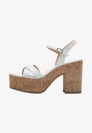 Sandale à plateforme en cuir blanc avec un talon en liège, bride de cheville et boucle en argent, présentée sur un fond blanc.