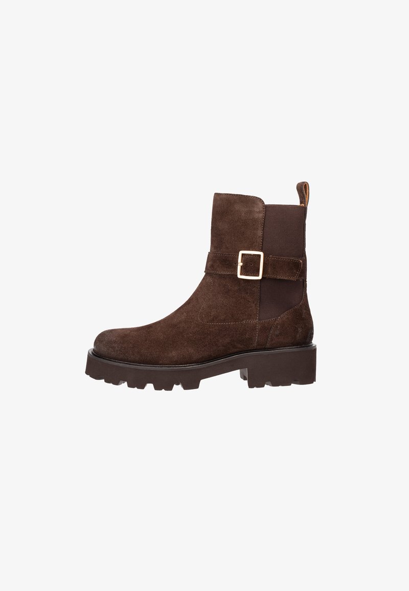 Stivale alla caviglia in suede marrone con suola spessa, pannello laterale elasticizzato e cinturino decorativo con fibbia dorata su uno sfondo bianco.