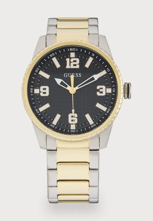 Silberne und goldene Edelstahl-Uhr mit einem schwarzen Zifferblatt, goldenen Akzenten, großen weißen Stundenmarkierungen und einer strukturierten Lünette.