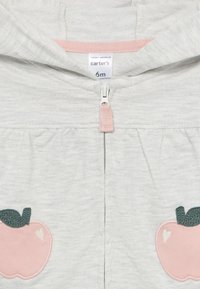 Helles graues Hoodie mit einem pinken Reißverschluss. Verfügt über zwei pinke, gestickte Apfeldesigns mit grünen Blättern und einem Herzen auf jeder Seite. Größe 6 Monate.