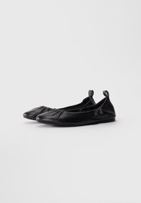 Pair of black leather ballet flats with gathered detailing and pull tabs at the heel, displayed on a white background.