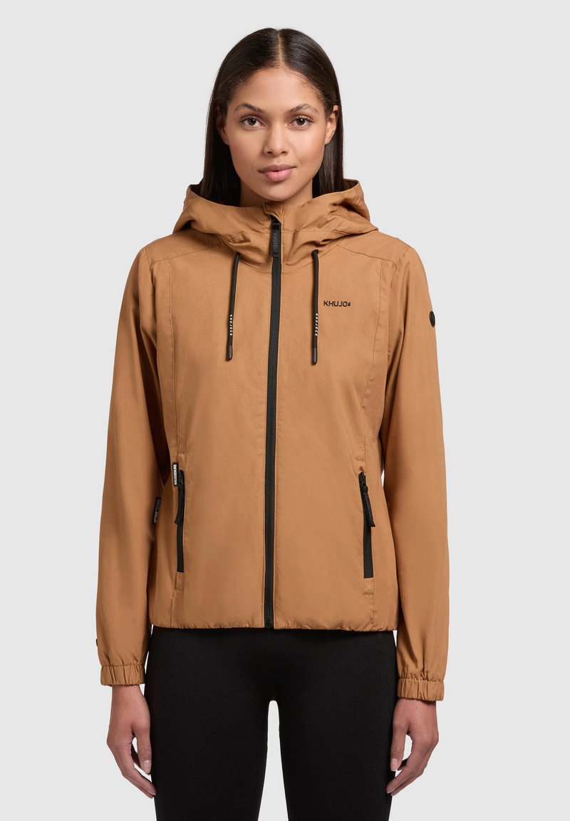 Leichte, braune, kapuzenjacke mit schwarzem Reißverschluss und Akzenten, elastischen Bündchen und mit Reißverschluss versehenen Taschen. Glatte Textur und lässige Passform.
