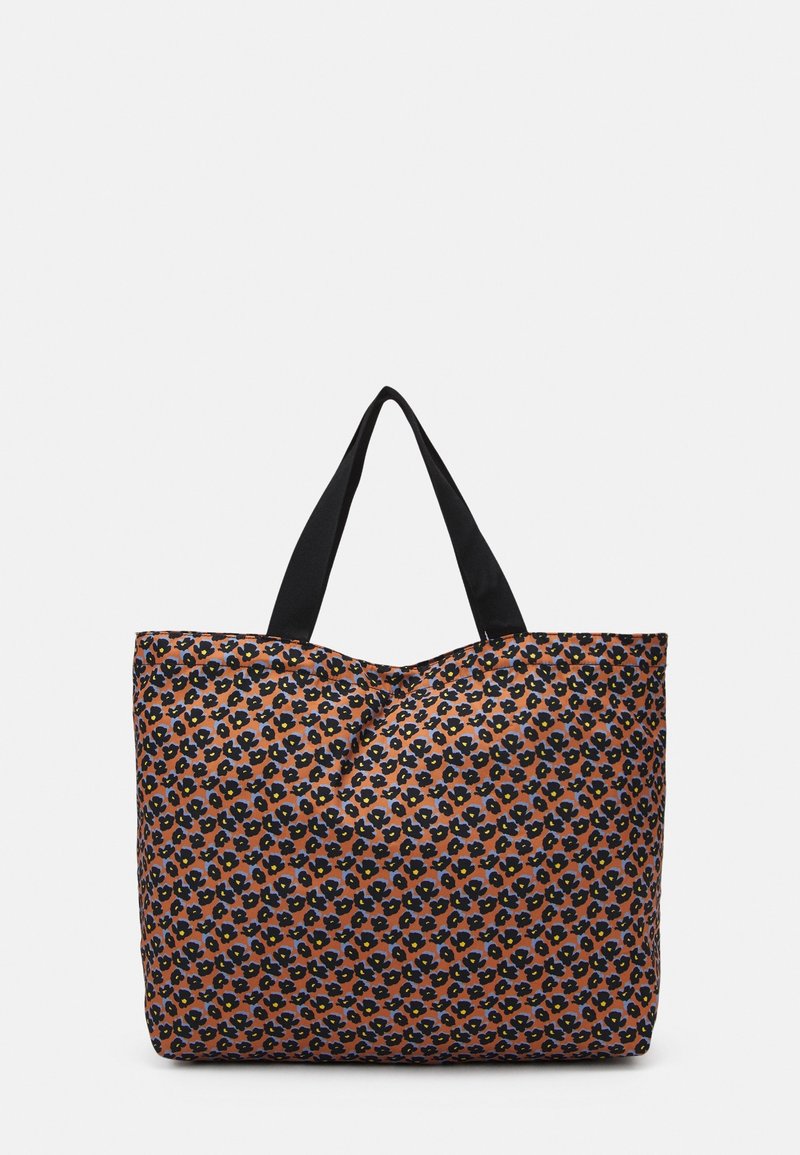 Sac fourre-tout en tissu à motifs avec un fond orange et un motif floral noir et bleu. Des anses noires sont solidement fixées.