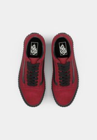Sneakers in suede rosso con accenti neri, suola in gomma, lacci neri e logo sulla linguetta. Design classico a basso profilo adatto per l'uso casual.