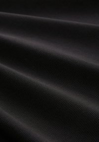 Black textured fabric with prominent ribbing, featuring smooth surface waves and a uniform color throughout.