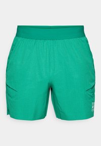 Πράσινες βερμούδες με υφή γεωμετρικού μοτίβου, ελαστική ζώνη στη μέση και πλαινές τσέπες. Το υλικό φαίνεται ελαφρύ και απορροφητικό από την υγρασία.