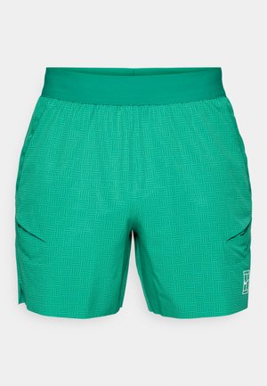 Pantaloni corti verdi con un motivo geometrico testurizzato, vita elastica e tasche laterali. Il materiale sembra leggero e traspirante.