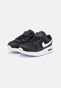 Mustat Nike-tennarit, joissa on verkkokangasta ja nahkaa, valkoisia yksityiskohtia ja tarranauha. Varustettu valkoisella pohjalla, jossa on Air-puskurointi.