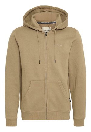 Zip-up hoodie in light tan cotton blend. Features a drawstring hood, two front pockets, and a small logo printed on the left chest.