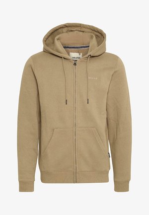 Zip-up hoodie in light tan cotton blend. Features a drawstring hood, two front pockets, and a small logo printed on the left chest.