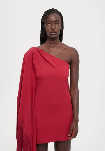 Vestido rojo de un solo hombro hecho de un tejido suave, con un diseño drapeado y detalles de flecos largos en un lado.