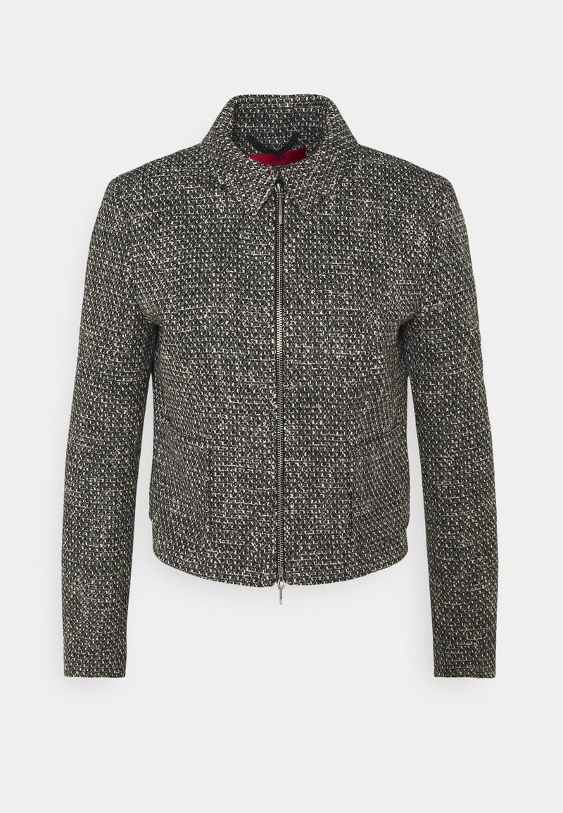 Chaqueta texturizada en blanco y negro con cuello con solapa, cierre frontal con cremallera y mangas largas. El tejido presenta un patrón tejido.