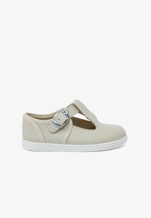 Lichtbeige leren Mary Jane-schoen met witte rubberen zool, gespsluiting, uitsnijdingen en decoratieve stiksels langs de randen.