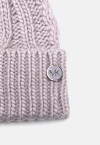 Cappello in maglia di un leggero color lavanda con un design a coste. Presenta un accento metallico con il logo sul risvolto. Tessuto morbido e strutturato.