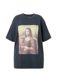 Černé oversized tričko s potiskem Mona Lisy na přední straně. Grafika je rámována žlutým okrajem. Měkký bavlněný materiál.