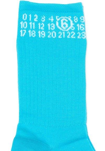 Chaussette bleue avec des chiffres blancs de 0 à 23 tricotés près du haut, avec un 6 encerclé parmi eux.
